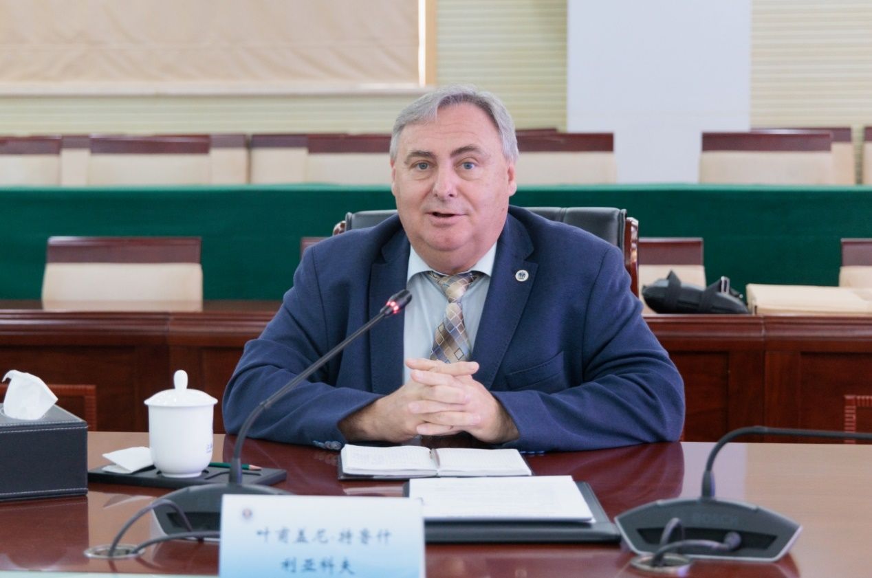 桌子前坐着穿西装的人中度可信度描述已自动生成